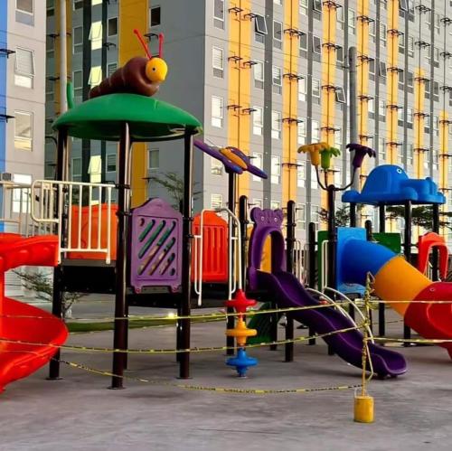 Un parque infantil con toboganes de colores y equipo de juego. en Kage-no-Wa Suite Netflix, Disney, HBO 2BR, en Manila