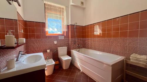 a bathroom with a tub and a toilet and a sink at Apartments Villa Eden in Kotor