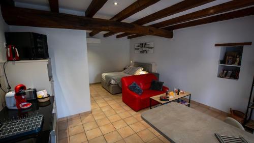 Una sala de estar con un sofá rojo y una mesa. en Le Petit Mona Althéa, en Civaux