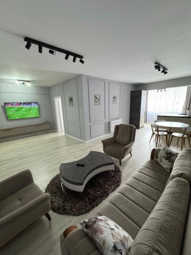 a large living room with a couch and a tv at Apartament modern 2 camere, Parcul Zăvoi in Râmnicu Vâlcea