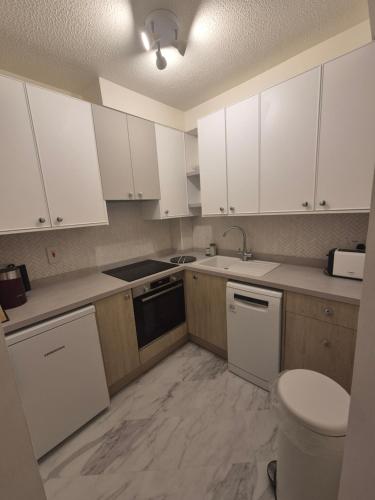 a kitchen with white cabinets and a sink at New Unique room beside Tramline in Citywest