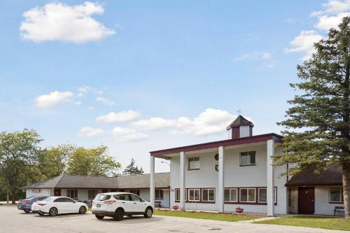 a building with cars parked in a parking lot at Heidelberg Motel by Capital O Bridgeport Frankenmuth MI Dixie HWY in Bridgeport