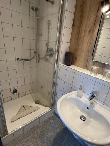 a bathroom with a shower and a sink and a shower at Aparthotel Domizil in Borkum