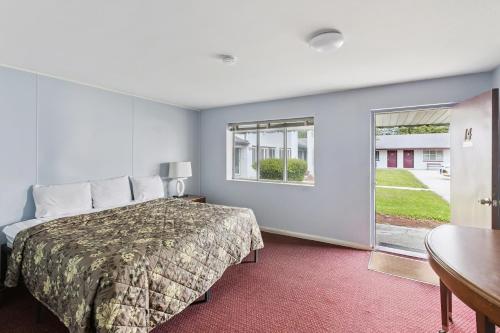 a hotel room with a bed and a window at Heidelberg Motel by Capital O Bridgeport Frankenmuth MI Dixie HWY in Bridgeport
