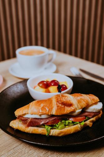 a sandwich on a plate on a table with a cup of coffee at Aruba Boutique & Art Hotel - Adults Only in Palm-Eagle Beach