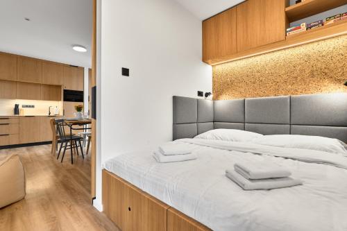 Un dormitorio con una cama grande con dos toallas encima. en Heřmánek by Mountain ways, en Abertamy