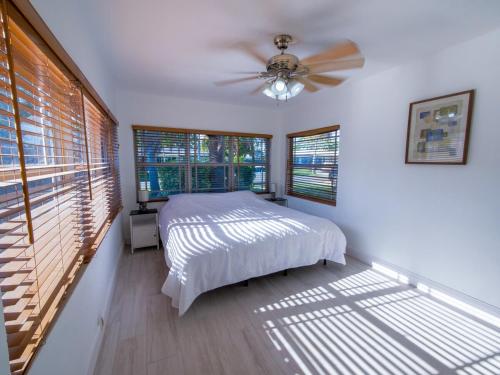 Un dormitorio con una cama y un ventilador de techo. en Dania Beach 4-bedroom house - Pool,Parking,Grill, en Dania Beach
