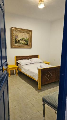 a bedroom with a bed and a picture on the wall at Dar Sidi Bou in Tozeur