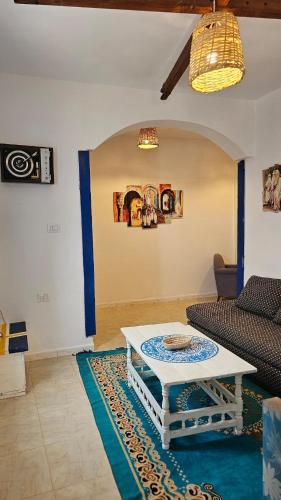 a living room with a table and a couch at Dar Sidi Bou in Tozeur