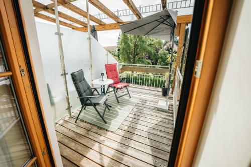 a balcony with a table and chairs and an umbrella at Schmiedbauerhof in Sankt Margarethen im Lavanttal