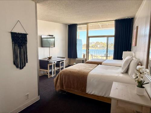 a hotel room with a bed and a desk and a window at Foghorn Harbor Inn in Los Angeles