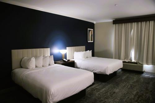 a hotel room with two beds and a window at Wyndham Lake Charles in Lake Charles