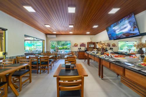 a restaurant with tables and chairs and a buffet at Pousada Tropicarim in Itacimirim