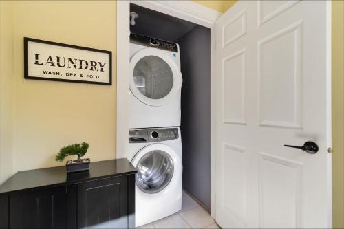 a laundry room with a washer and dryer next to a door at Piece of Paradise in Sooke