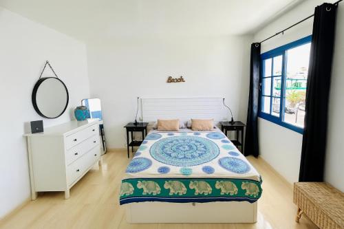 ein Schlafzimmer mit einem Bett, einer Kommode und einem Spiegel in der Unterkunft VILLA BARRACUDA - "Seaview 3min walk to the beach" in Playa Blanca