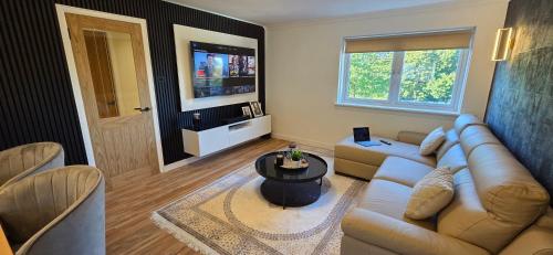 a living room with a couch and a table at Malina at The Green in Glasgow