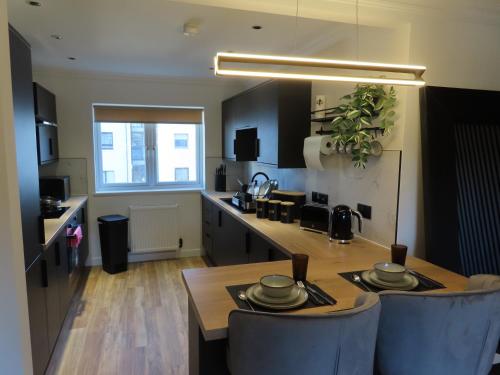Una cocina con una mesa y sillas en una habitación. en Malina at The Green, en Glasgow
