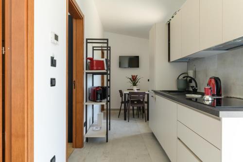 Una cocina con gabinetes blancos y una mesa. en Tempo Lento, en Ostuni