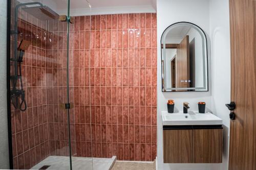 une salle de bain avec une douche avec un lavabo et un miroir dans l'établissement œil de la vallée, à Marrakech