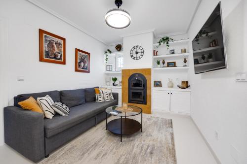a living room with a couch and a table at CB Living - Cozy condo with patio, Playa Flamenca in Orihuela Costa