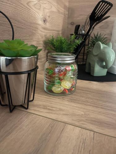 a jar of vegetables on a table with a potted plant at Nuit Magique en Love Room avec Jacuzzi Privé in Vierzon