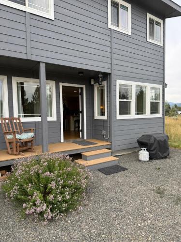 a gray house with a porch with a chair and a bench at Tamarack Retreat Donnelly ID in McCall