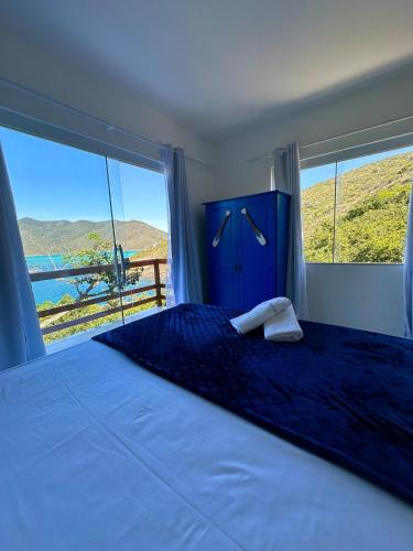 a bedroom with a large bed with a large window at Greek House Premium in Arraial do Cabo