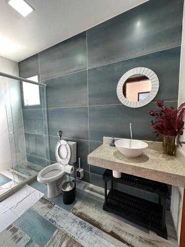 a bathroom with a sink and a toilet and a mirror at Greek House Premium in Arraial do Cabo