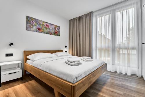 Un dormitorio con una cama y una ventana grande. en Kopřiva by Mountain ways, en Abertamy