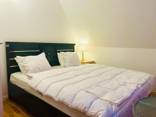 a bedroom with a large bed with white sheets and pillows at Comfortable room in Malmo- Husievägen 100 in Malmö