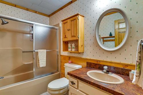 a bathroom with a sink and a toilet and a mirror at Waterfront Lake Pleasant Retreat with Private Dock in Lake Pleasant