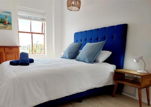 a blue bed with a blue headboard in a bedroom at 8 Eden Villa in Yzerfontein