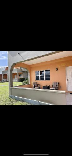 two pictures of a house with chairs in the courtyard at Dove Cove Comfort Suites in Rat Island