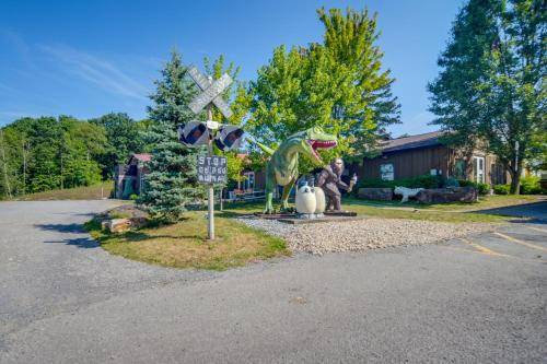 a statue of a dinosaur next to a railroad crossing at Red NY Central, Converted Railcar in DuBois! in Adrian Furnace