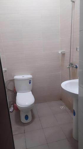 une salle de bain avec des toilettes blanches et un lavabo dans l'établissement Appartement Moderne PanneaUx Solaires Golf, Bamako, à Bamako