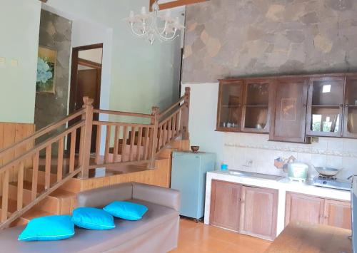 Una cocina con una escalera y un sofá con cojines azules. en Talita Mountain Resort, en Ciseureuh