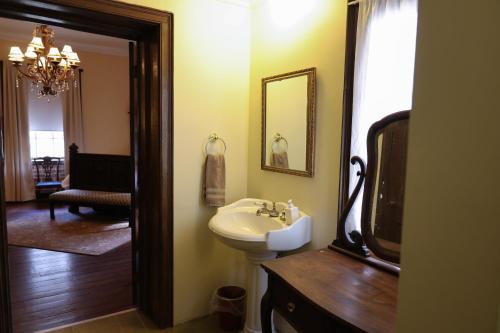Un baño con lavabo, espejo y televisor. en Ormond Manor, en Destrehan