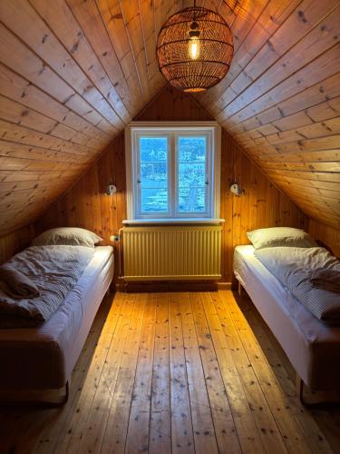 a attic bedroom with two beds and a window at Beautifully restored traditional home in old town Tórshavn in Tórshavn