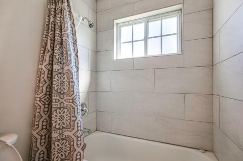 a bathroom with a shower with a window at Central Menomonee Falls Condo WFH Friendly in Menomonee Falls