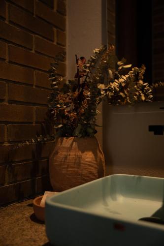 a bathroom sink with a vase with a plant in it at Casa Rose Hotel in Carmen de Viboral