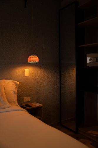 a dark room with a bed and a lamp at Casa Rose Hotel in Carmen de Viboral