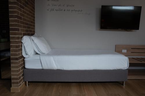 a bed in a room with a flat screen tv at Casa Rose Hotel in Carmen de Viboral