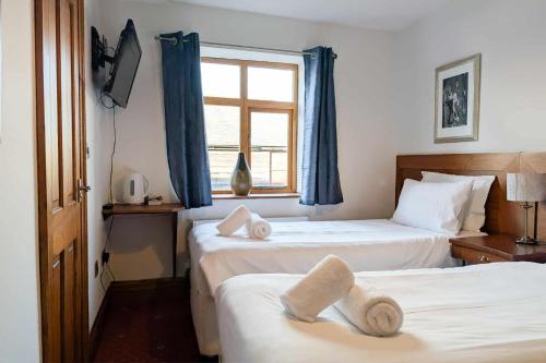 a hotel room with two beds with towels on them at The Castle Inn in Wigmore
