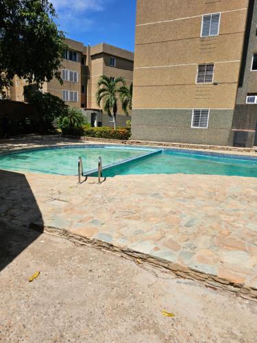 zwei Personen stehen in einem Pool vor einem Gebäude in der Unterkunft Apartamento Moderno Margarita in El Valle del Espíritu Santo