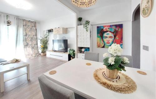 un soggiorno con un tavolo con un vaso di fiori di Nice Apartment In Puebla De Farnals a Las Canteras