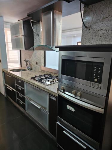 eine Küche mit Mikrowelle und Herd in der Unterkunft Apartamento Moderno Margarita in El Valle del Espíritu Santo