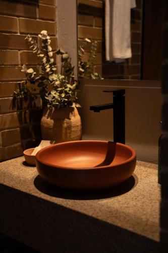 a bathroom with a wooden bowl sink on a counter at Casa Rose Hotel in Carmen de Viboral