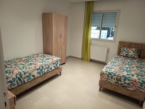 a bedroom with two beds and a window at Le Hammamet centre in Hammamet