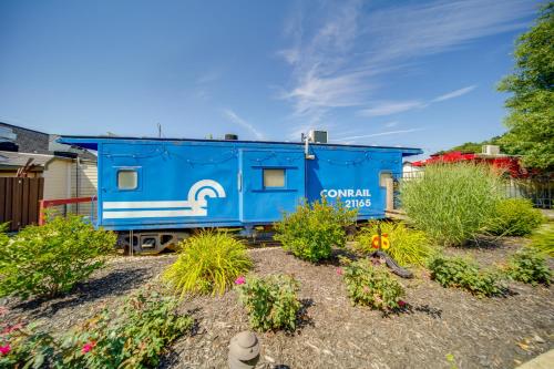 a blue train car in a yard with plants at Choo Choo Blue, Converted Railcar in DuBois! in Adrian Furnace