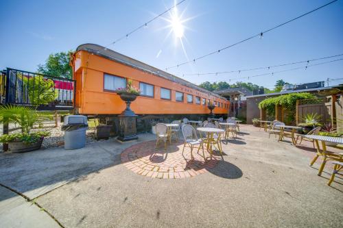 an orange train is parked next to tables and chairs at Choo Choo Blue, Converted Railcar in DuBois! in Adrian Furnace